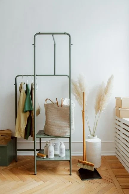 A couple wrapping furniture in a bright apartment, preparing to move.